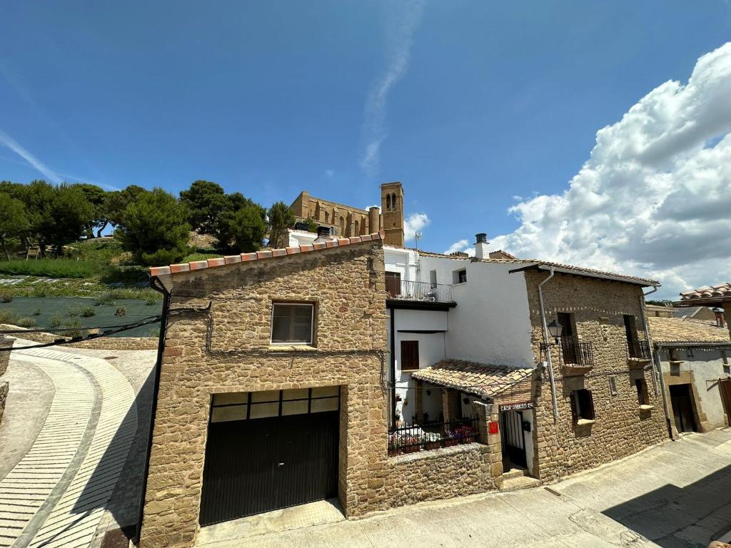 a brick building with a garage on a street at Casa Janices in Artajona