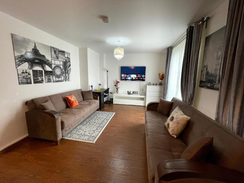 a living room with a couch and a tv at London Stratford Luxury House, 5 minutes walk Station, Westfield, 3 Bedrooms 3 Bathrooms, Reception, Garden, Parking in London