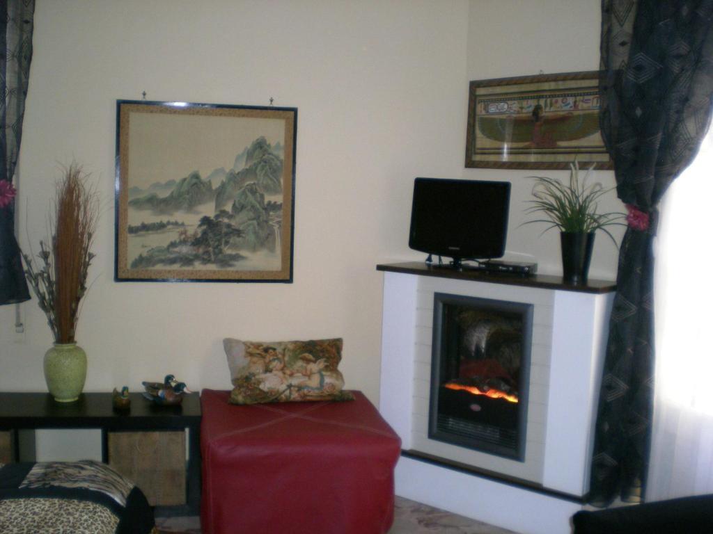 salon z telewizorem i kominkiem w obiekcie Orizzonte B&B w Cefalù