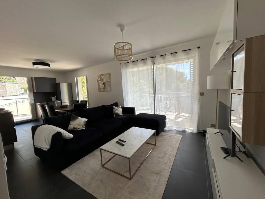 a living room with a black couch and a table at Prestige View 121 in Èze