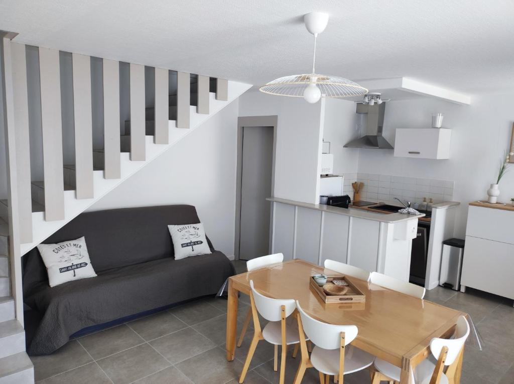 ein Wohnzimmer mit einem Sofa und einem Tisch in der Unterkunft Location saisonnière à St Hilaire de Riez in Saint-Hilaire-de-Riez