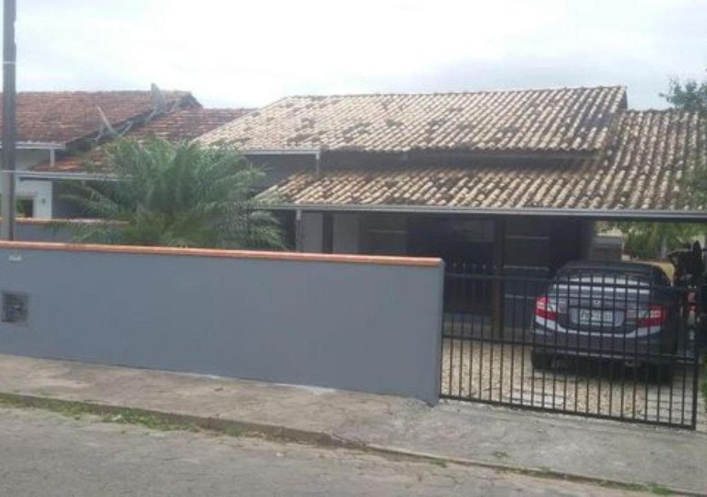un coche aparcado en un garaje junto a una valla en Casa Em Penha Sc, en Penha