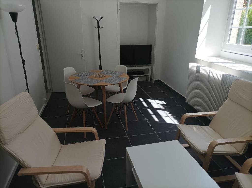 um quarto com uma mesa e cadeiras e uma televisão em O'Couvent - Appartement 62 m2 - 2 chambres - A513 em Salins-les-Bains