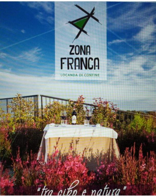 a table in a field of flowers with a sign at Locanda Zona Franca in San Benedetto del Tronto