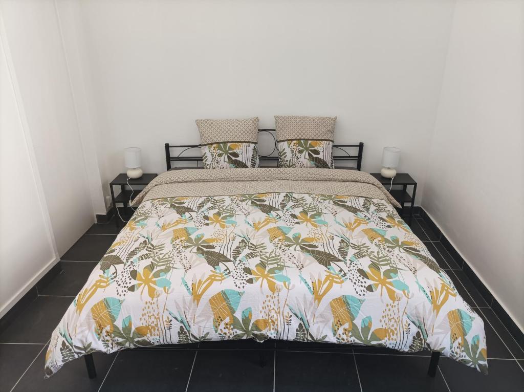 a bedroom with a bed with a floral bedspread at O&#39;Couvent - Appartement 62 m2 - 2 chambres - A513 in Salins-les-Bains