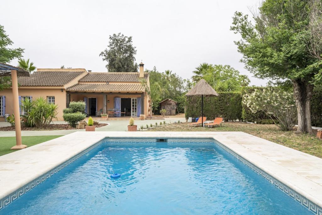 a swimming pool in front of a house at Villa Laforge in Carmona