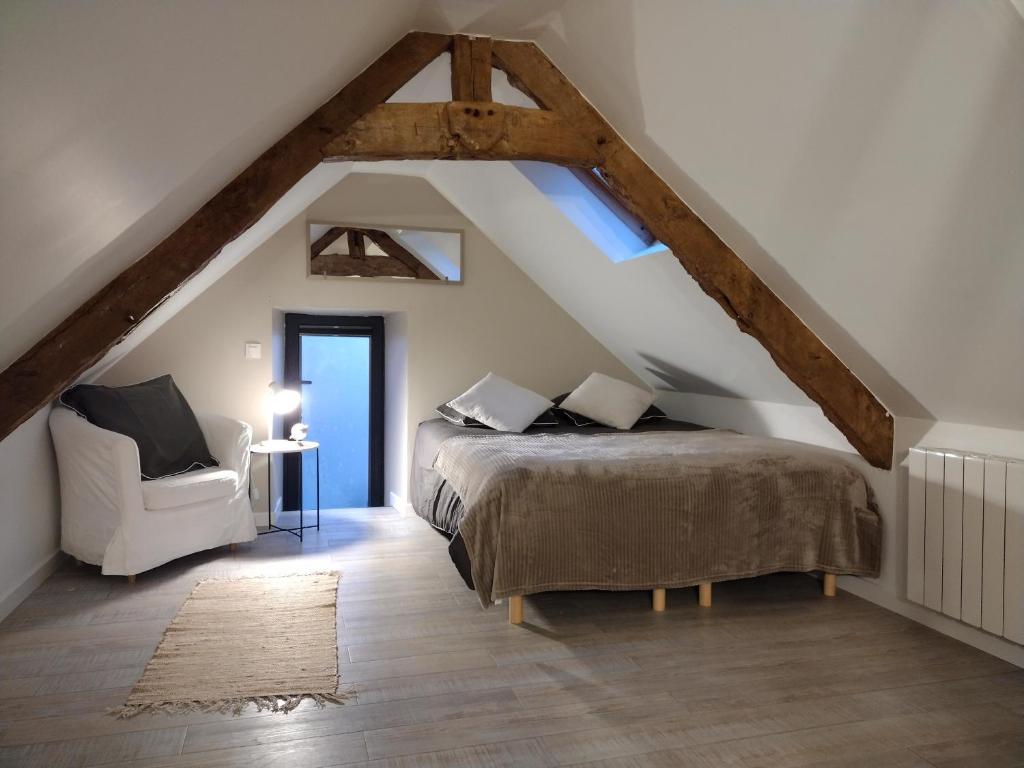1 dormitorio en el ático con 1 cama y 1 silla en Gîte charmant typique Breton Ti Quartier en Pordic