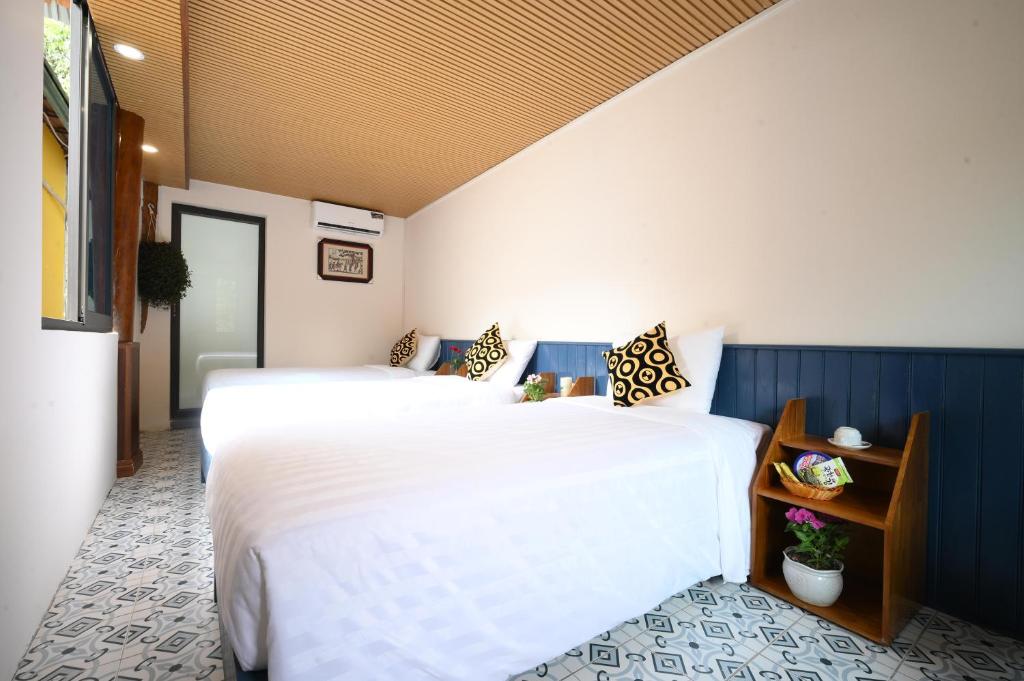 two beds in a room with white and blue at Catba Papillon Garden Bungalows & Resort in Cat Ba