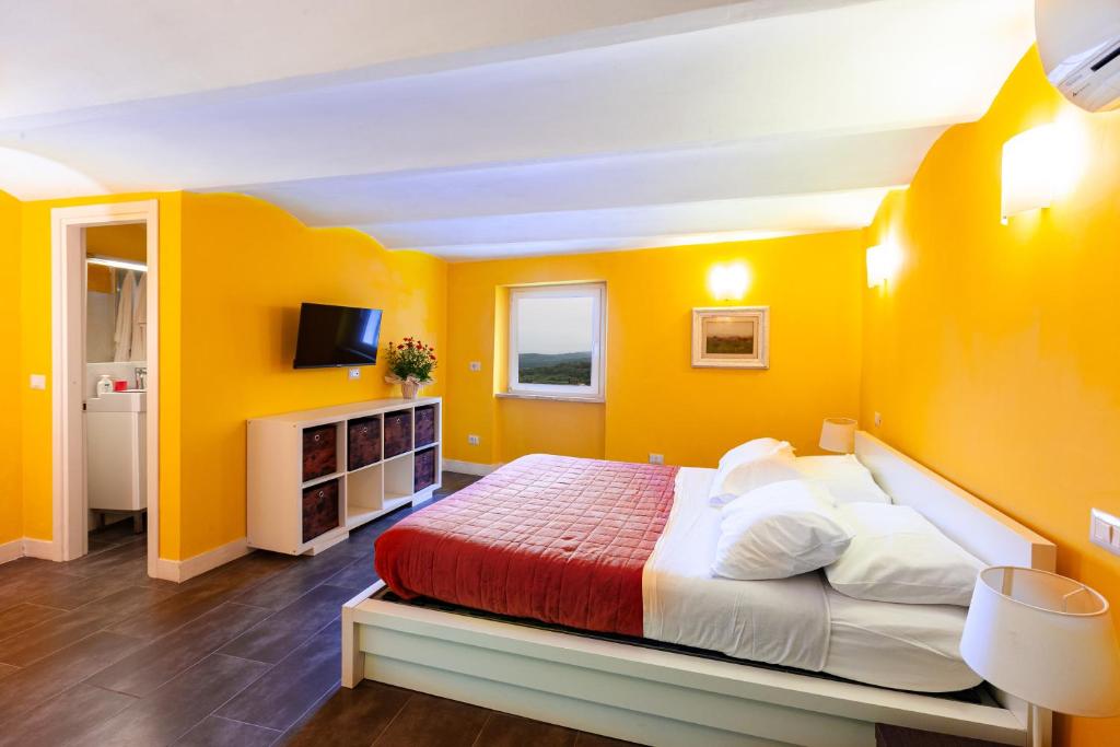 a bedroom with yellow walls and a bed in a room at Da Aurora al 27 in Manciano