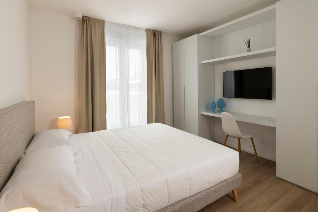 a bedroom with a bed and a desk and a television at The Palm Riccione in Riccione