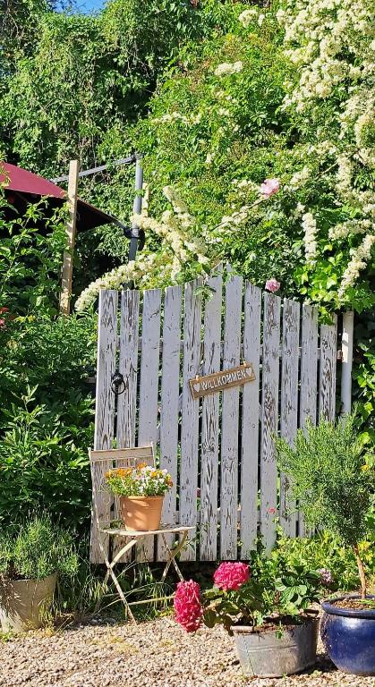 a garden with a wooden fence and a bench with flowers at Gemütliche Waldrandlage in Badenweiler Sehringen Ferienwohnung in Badenweiler
