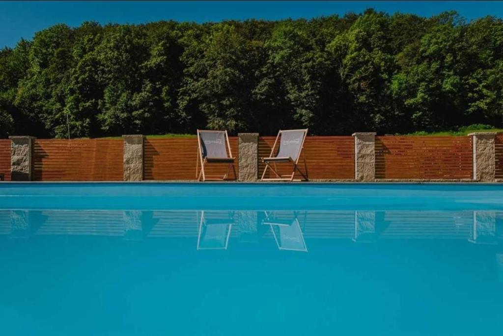 - deux chaises longues installées à côté de la piscine dans l'établissement Soba pri nam, 