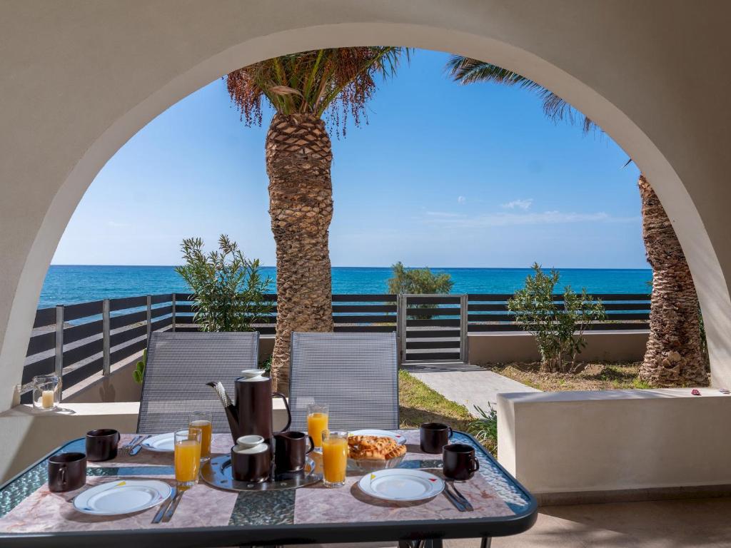 a dining table with a view of the ocean at Atalanti Seaside Junior Suites in Keratokampos