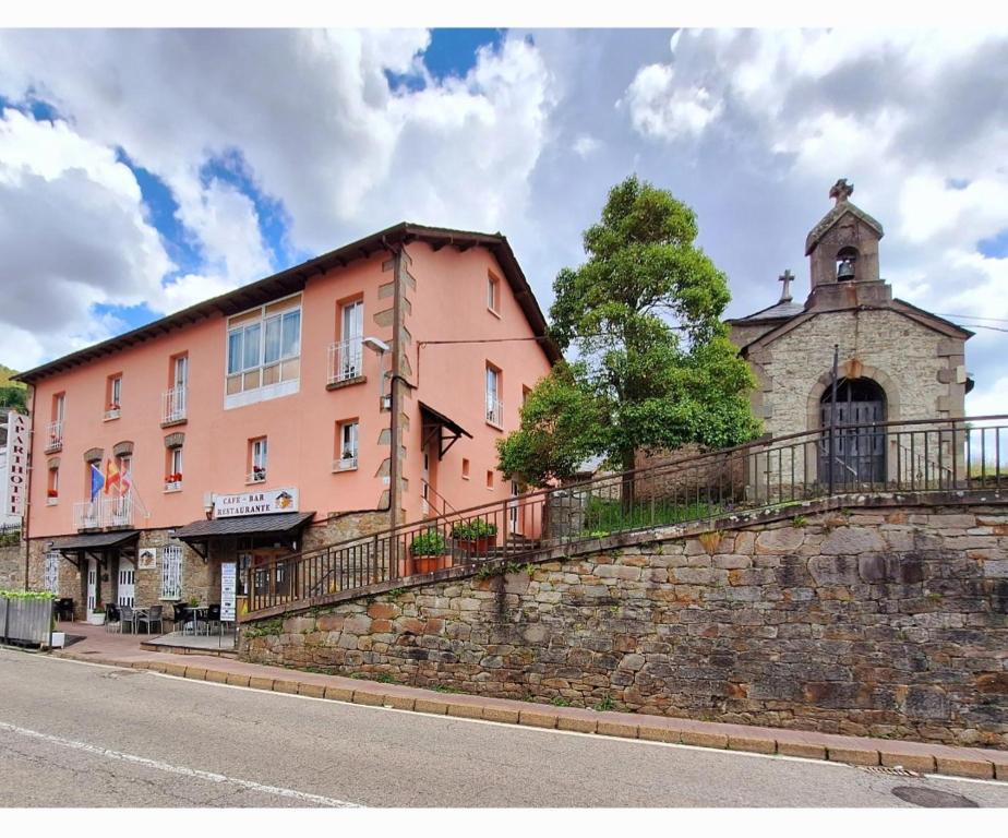 um edifício ao lado de uma parede de pedra em Apartahotel portal de leon em Caboalles de Abajo