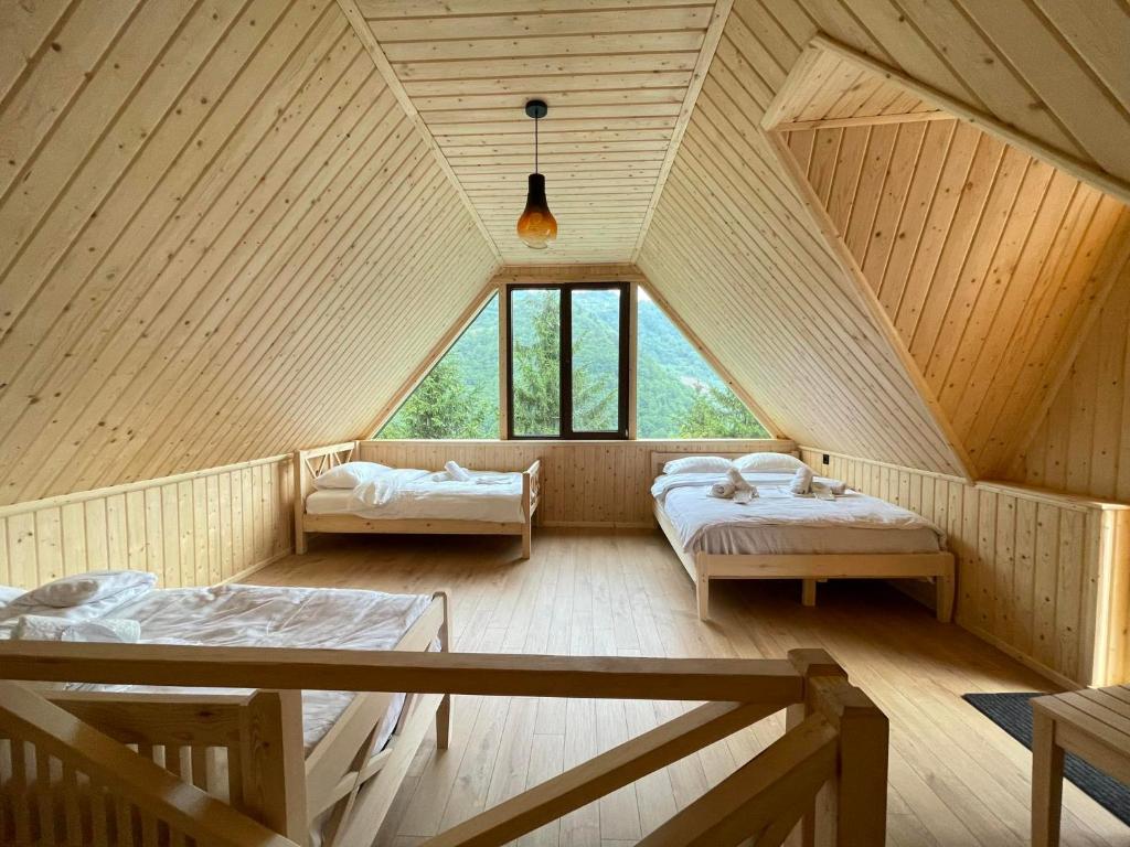 a attic room with two beds and windows at Vaio Resort in Keda in Vaio