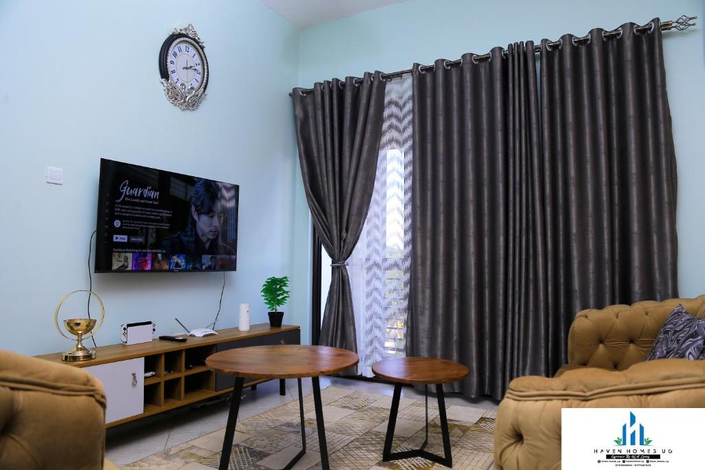 sala de estar con sofá y mesa frente a una ventana en Haven Homes Ug H07 confy stay en Kyambogo