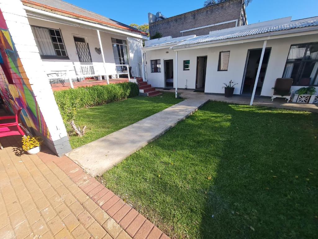 a backyard of a house with a grass yard at Melville House in Johannesburg