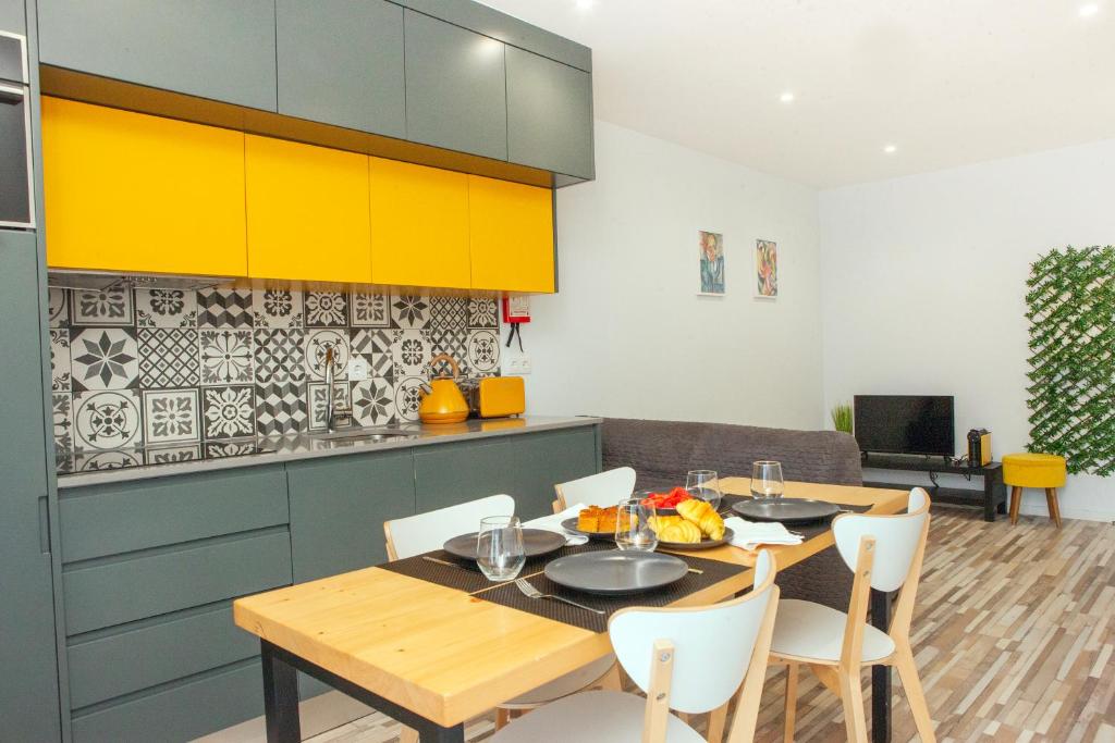 a kitchen with a table and chairs and yellow cabinets at Host Wise - Amadeo Apartments in Vila Nova de Gaia