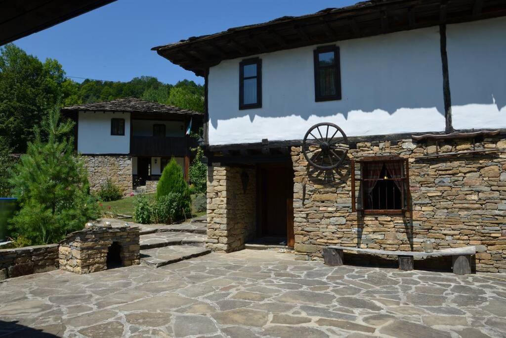 a stone house with a stone courtyard in front of it at Къща за гости КИМ in Apriltsi
