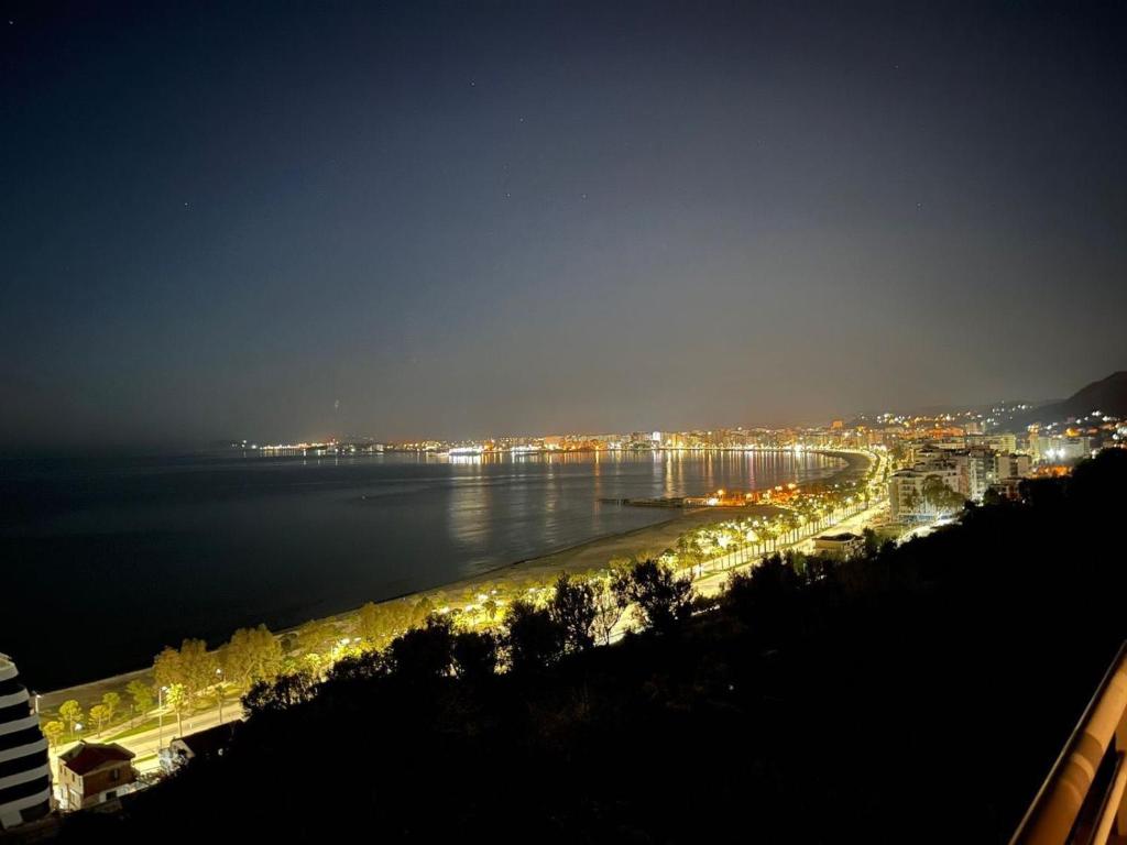 Blick auf den Strand in der Nacht mit Lichtern in der Unterkunft Vlora City Apartments in Vlorë