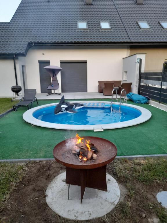 a fire pit in a backyard with a pool at Wypoczynek nad Dunajcem 