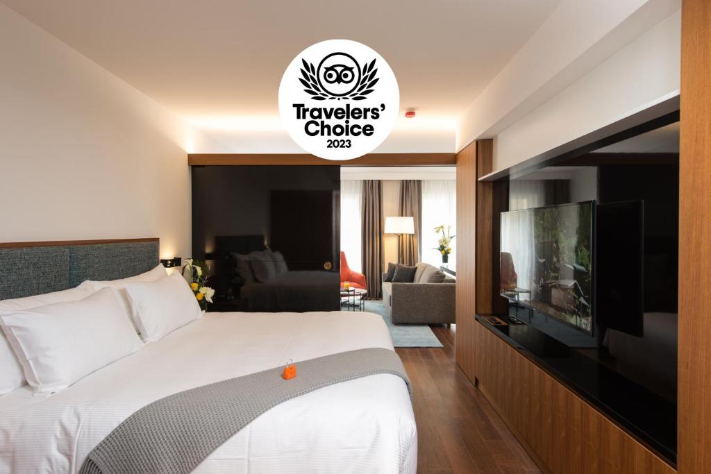 a hotel room with a bed and a flat screen tv at Fraser Suites Geneva - Serviced Apartments in Geneva