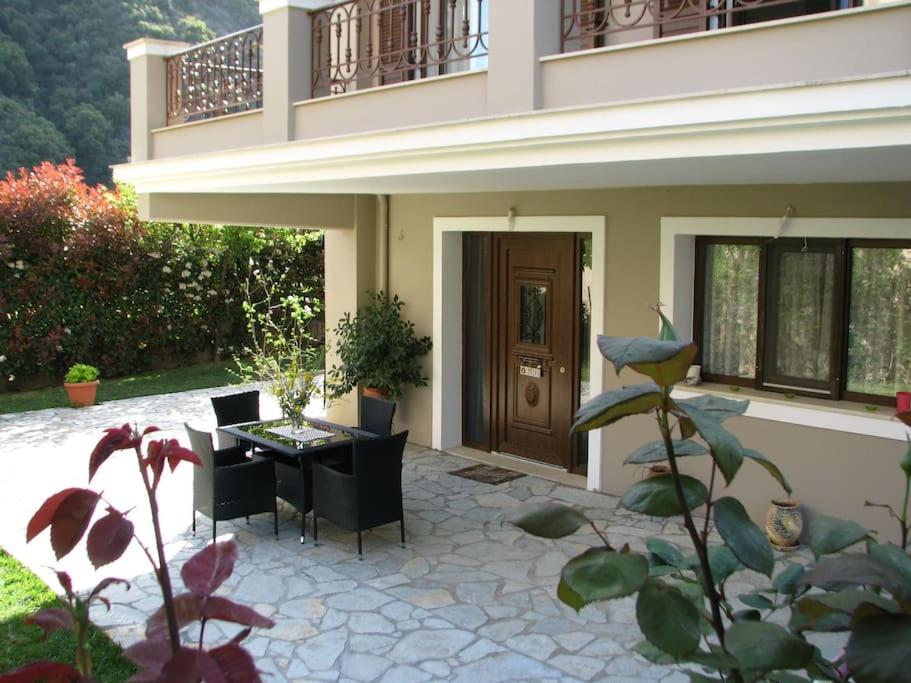 a house with a patio with a table and chairs at Sweet Home near Patras in Patra