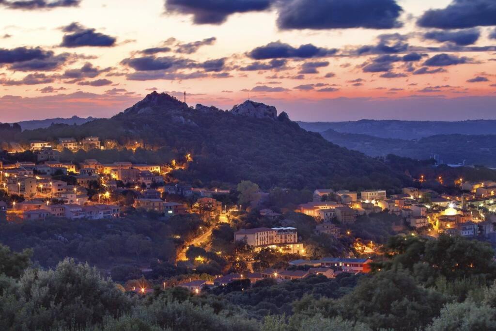 een stad 's nachts met een berg op de achtergrond bij Casa Rosalina Sardinia Italy in Luogosanto