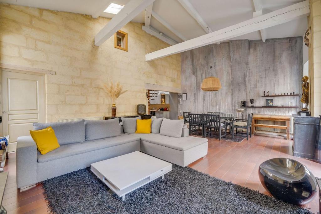 a living room with a couch and a table at Le 22 - Magnifique appartement en plein cœur des Chartrons in Bordeaux