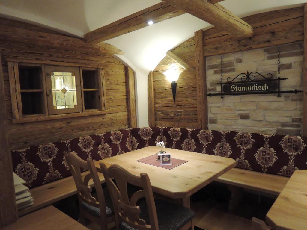ein Esszimmer mit einem Tisch und einem Sofa in der Unterkunft Gasthof Stocker in Landsham