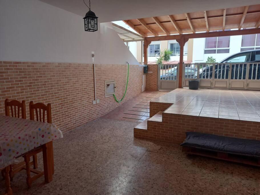 Pokój z ceglaną ścianą i patio ze stołem w obiekcie MyCasa w mieście Morro del Jable