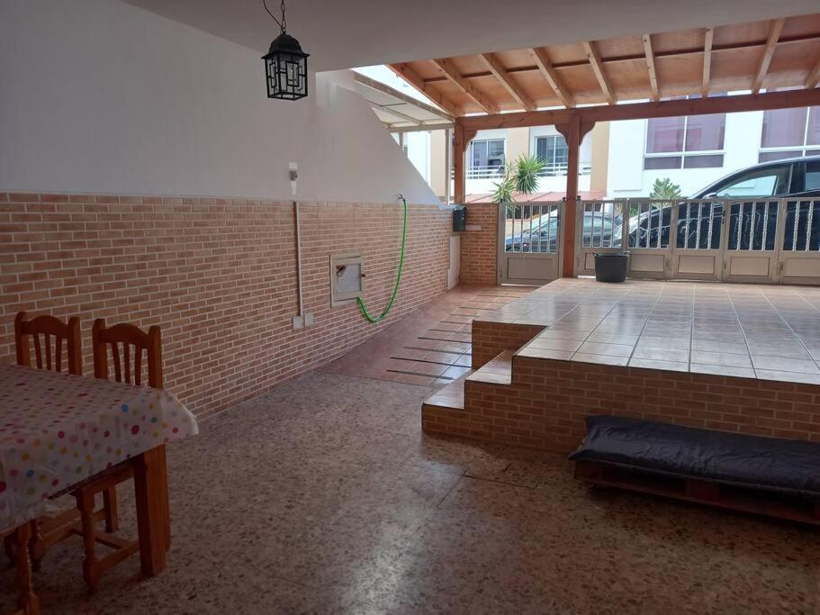 una camera con un muro di mattoni e un patio con tavolo di MyCasa a Morro del Jable