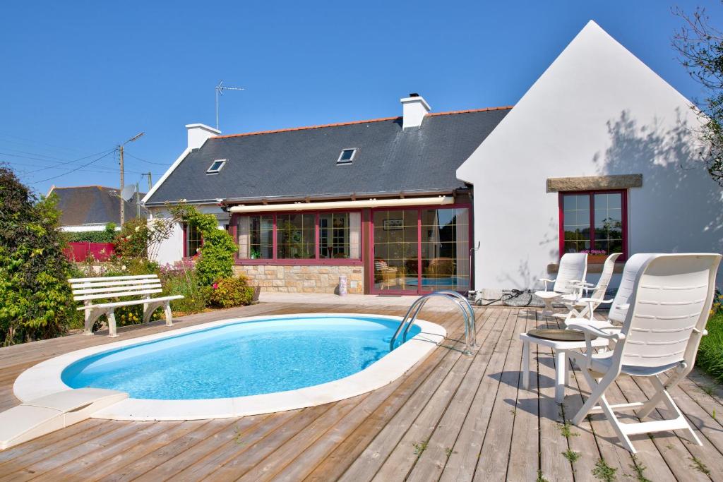 une terrasse avec une piscine, des chaises et une maison dans l'établissement Echappee Bretonne entre ocean et nature, à Plomeur