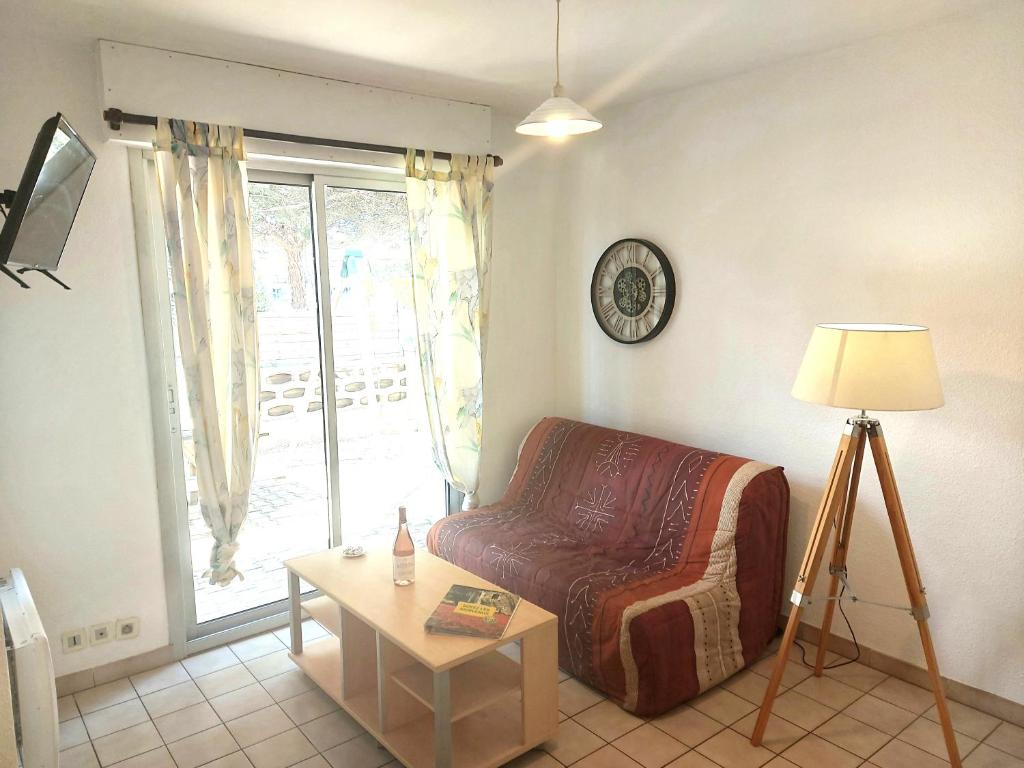 un salon avec une chaise et une table dans l'établissement soleil catalan ok chéques vacances animaux rdc 150m mer 4pers wifi 2ch, à Saint-Cyprien