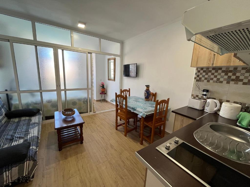 a kitchen and living room with a table and chairs at VIS3 - Estudio con Wifi, Centro a 200 metros, Playa a 850 metros in Torremolinos