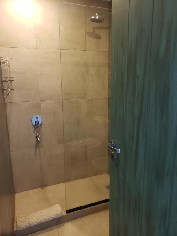 eine Dusche mit Glastür neben einer Dusche in der Unterkunft Para quedarse - SalePatagonia in San Martín de los Andes