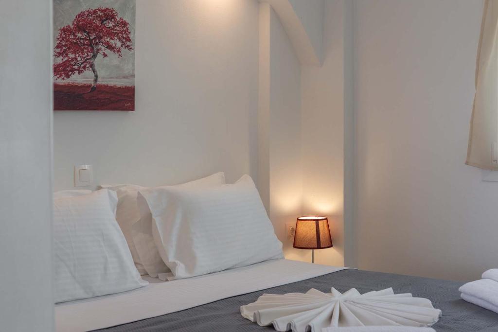 a bedroom with a bed with white pillows and a tree at Sunset Village 5 in Paleochori