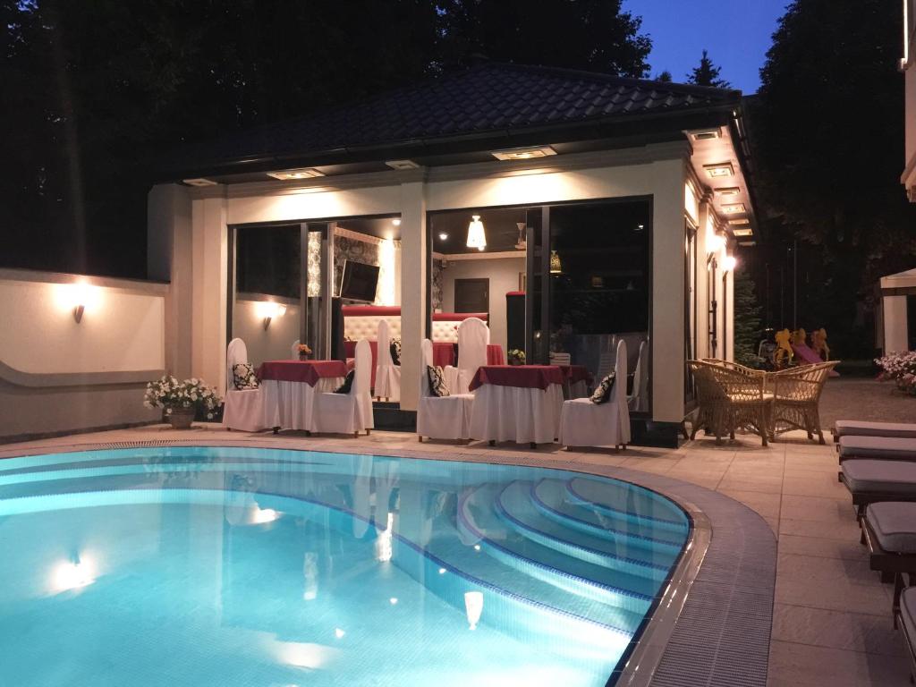 una piscina frente a un restaurante por la noche en Penthouse Apartment in Hotel Eney, en Leópolis
