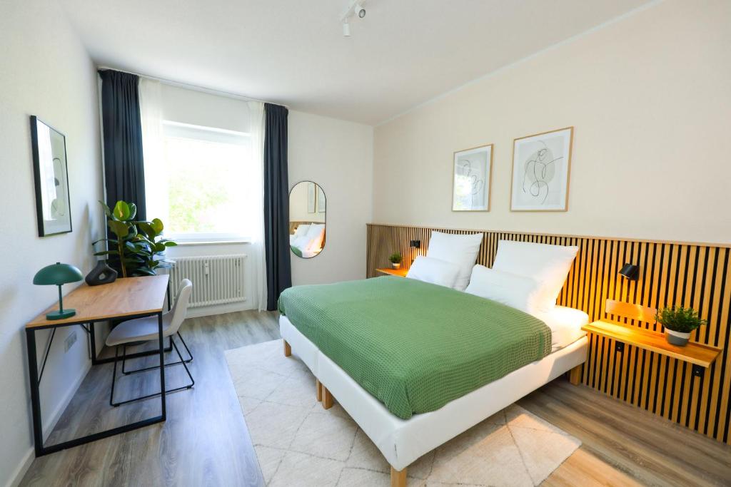 een slaapkamer met een bed en een bureau bij 75qm Luxusapartment in perfekter Lage in Bochum