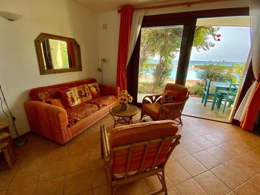 un soggiorno con divano e tavolo di Porto Antigo - Charming & peaceful apartment overlooking pool and sea a Santa Maria