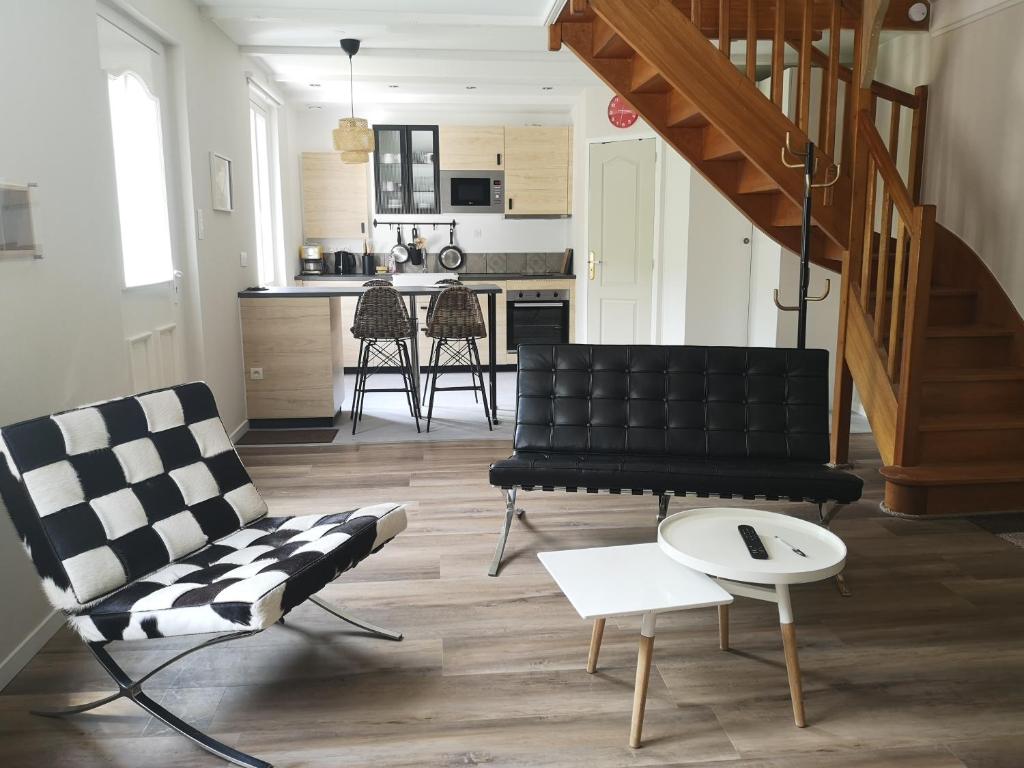 uma sala de estar com um sofá preto e uma mesa em maison au calme à Lannion entre mer et ville em Lannion