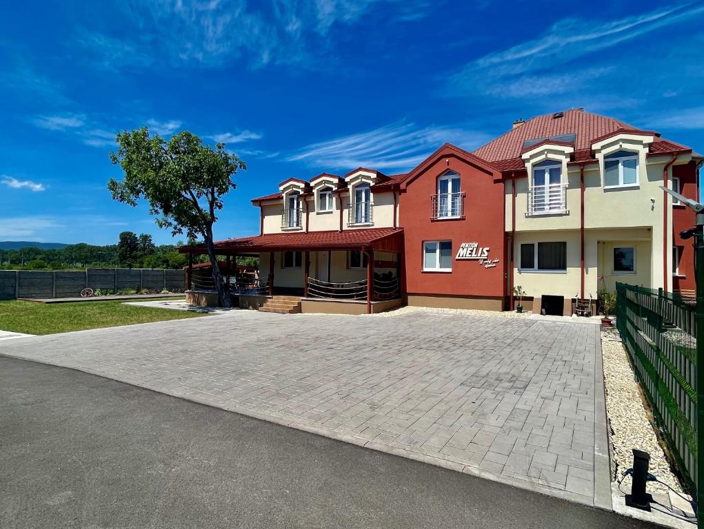 uma casa grande com uma entrada em frente em Penzión MELIS em Trebišov