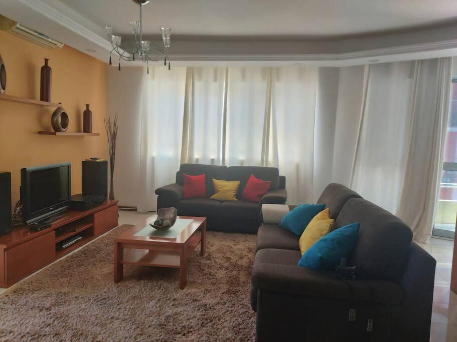 a living room with a couch and a tv at Apartamento acolhedor na Cidade da Praia in Praia