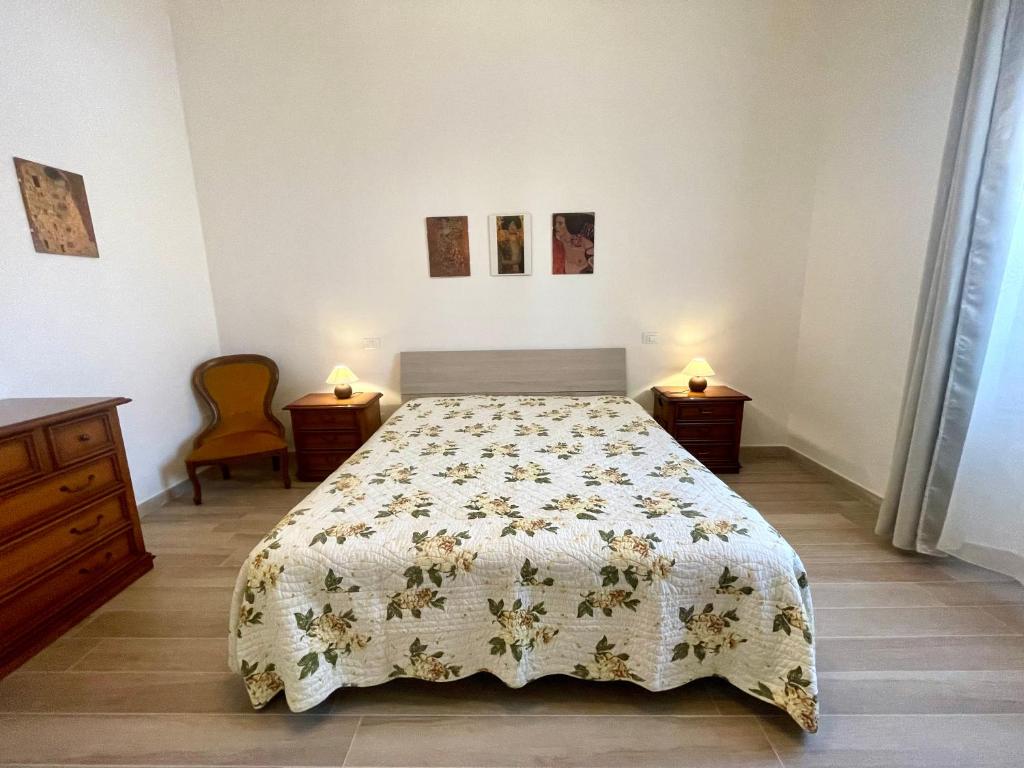 1 dormitorio con 1 cama con colcha de flores en Casa La Palma, en Vecchiano