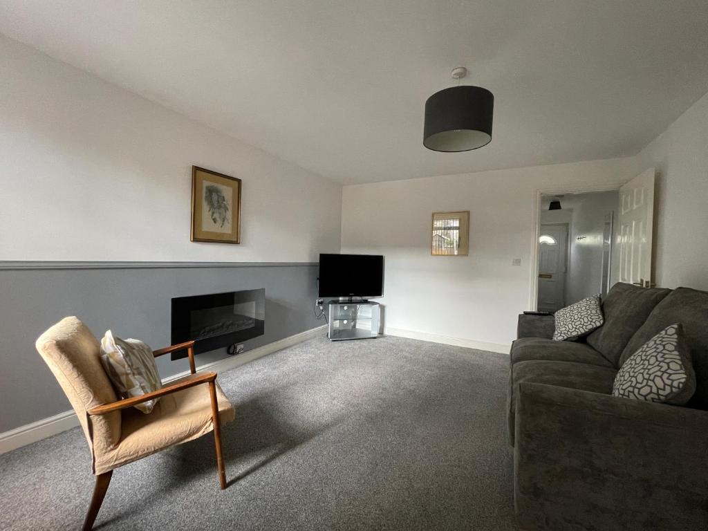 a living room with a couch and a tv at Cosy & Comfortable Apartment w/Parking in Worksop