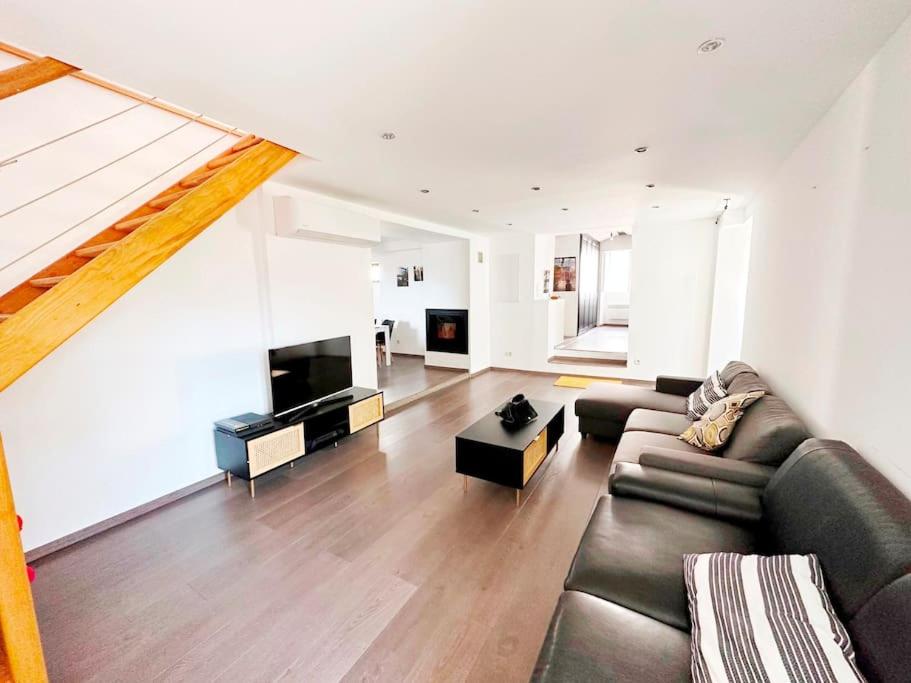 a living room with a couch and a television at Magnifique duplex de 130 m² à Corte (centre ville) in Corte