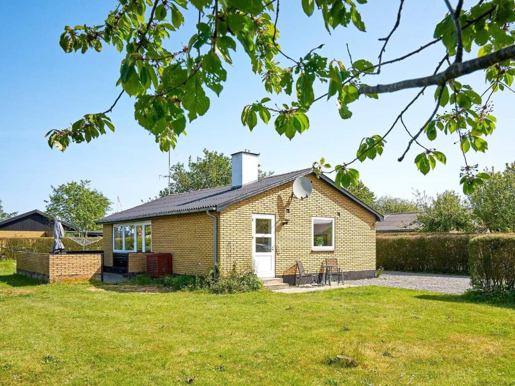 une petite maison en brique avec une pelouse dans l'établissement Holiday home Rønne VI, à Rønne
