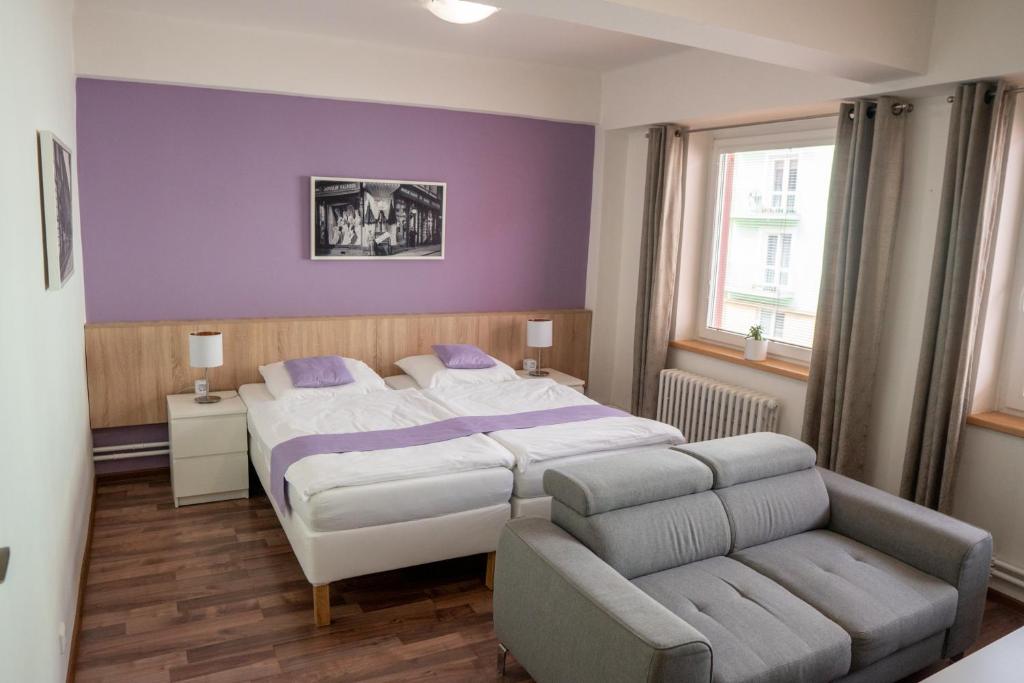 a bedroom with a large bed and a couch at Penzion Staré Louny in Louny