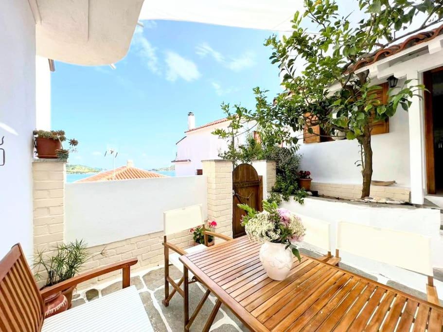 Un patio con una mesa y sillas de madera. en Traditional House Mataki, en Skiathos