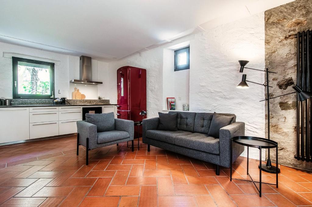ein Wohnzimmer mit einem Sofa und 2 Stühlen in der Unterkunft Casa Brocchi by Quokka 360 - unique design house with garden in Sorengo
